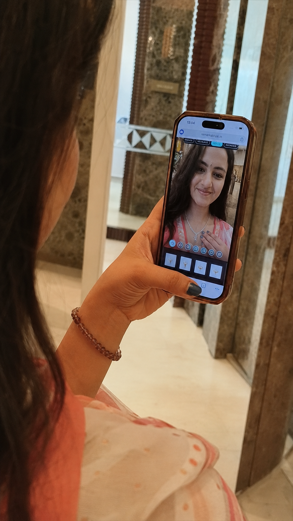 Influencer viewing a necklace on herself with RemARkablyAI virtual try-on